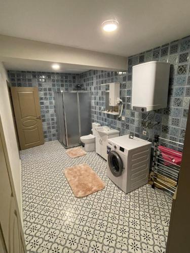 a bathroom with a sink and a washing machine in it at Kıymet Aydogdu in Alaçatı