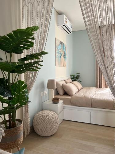 a bedroom with a bed and a large plant at Oriole Havana Salalah in Salalah