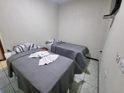 two beds sitting next to each other in a room at Quartus Hotel in Água Boa