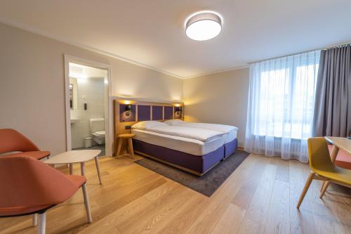 a bedroom with a bed and a bathroom at Dialoghotel Eckstein in Zug