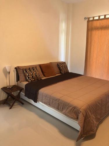 a large bed in a bedroom with a window at Casa Seaside Rayong by Chate in Rayong
