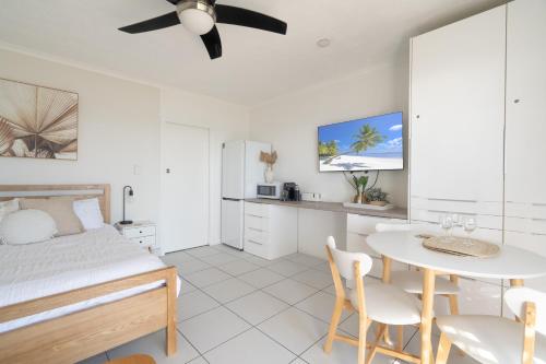 a bedroom with a bed and a table and chairs at Lousha Bach Dolphin Heads in Eimeo