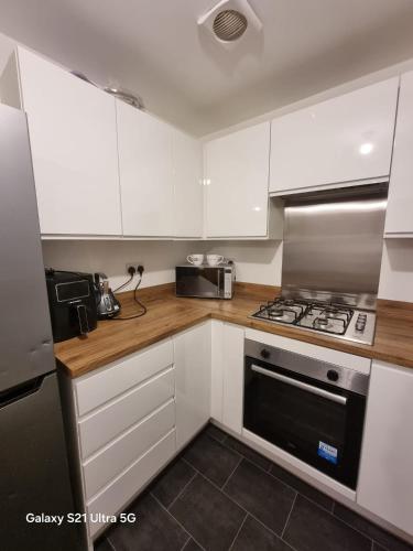 a kitchen with white cabinets and a stove top oven at Beluca homes Acklam in Middlesbrough