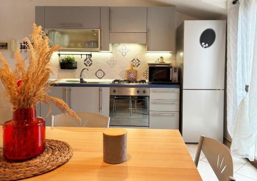 a kitchen with a table and a white refrigerator at Holihome D'Auri in Tortoreto Lido