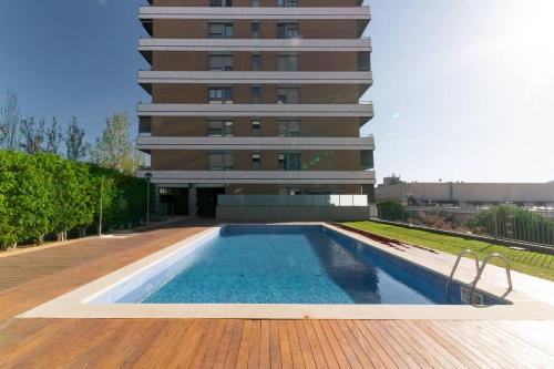 a building with a swimming pool in front of a building at Penthouse with Private Terrace & Pool Access in Cornellà de Llobregat