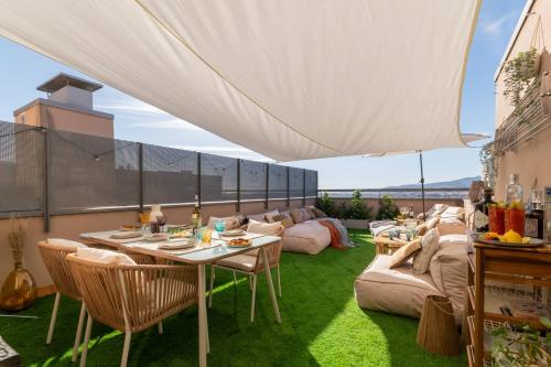a patio with a table and chairs and a couch at Penthouse with Private Terrace & Pool Access in Cornellà de Llobregat