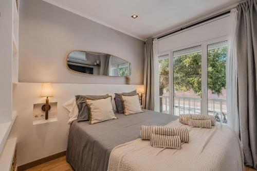 a bedroom with a large bed with a large window at NEW Refurbished Modern Apartment in Barcelona