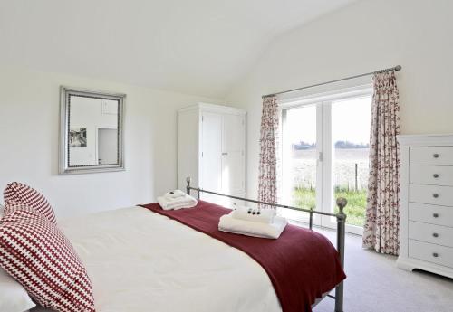 a bedroom with a bed and a large window at 3 Bed in Snape oc-2wadd in Snape