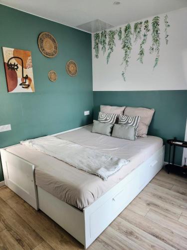 a bed in a room with green walls at Chalet Cosy avec option Jacuzzi in Saint-Genès-de-Fronsac