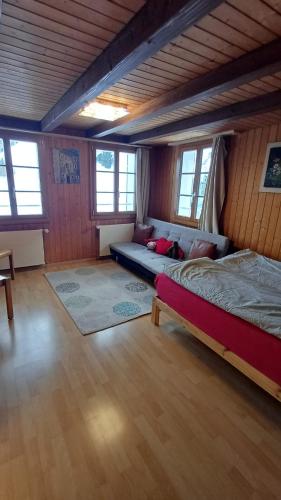 a bedroom with a bed and a couch in a room at Familienzimmer mit Bergblick in Emmetten