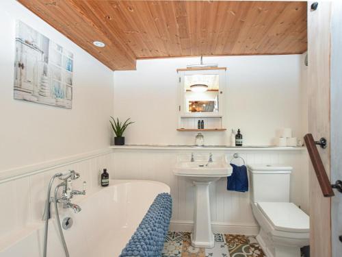 a bathroom with a tub and a toilet and a sink at 1 Bed in Spalding oc-75073 in Surfleet