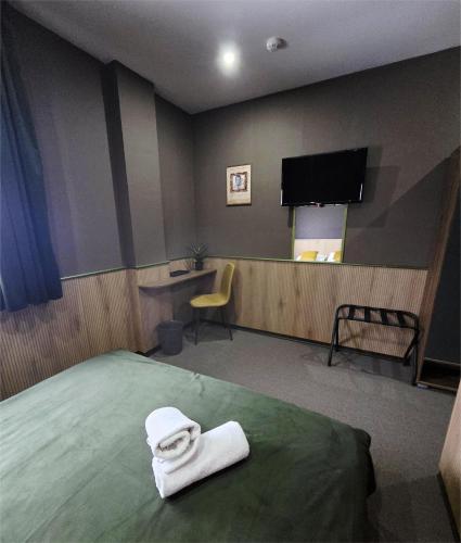 a room with a bed with a face towel on it at Garni Hotel & Spa Nicolo in Kruševac