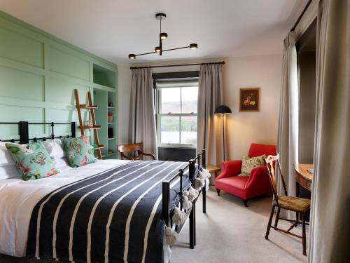 a bedroom with a bed and a red chair at The Brackenrigg Inn in Watermillock