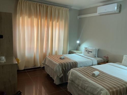 a hotel room with two beds and a window at Punyu International Hotel 