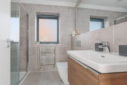 a bathroom with a sink and a toilet and a shower at Stonehaven in Warmwell