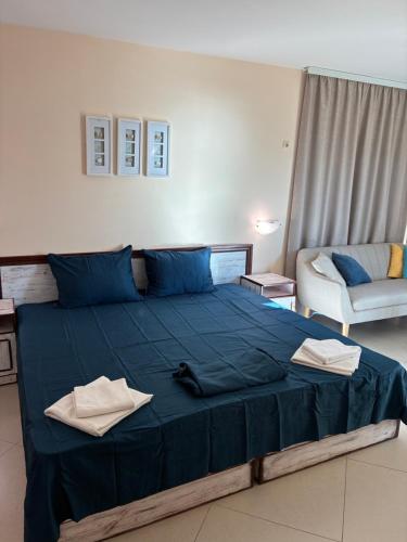 a large blue bed in a room with a couch at Seaside Apartment Golf Coast in Topola