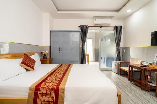 a bedroom with a large bed and a living room at Helen Airport Hotel in Ho Chi Minh City