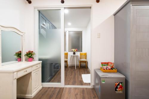 a bathroom with a sink and a mirror and a table at Helen Airport Hotel in Ho Chi Minh City