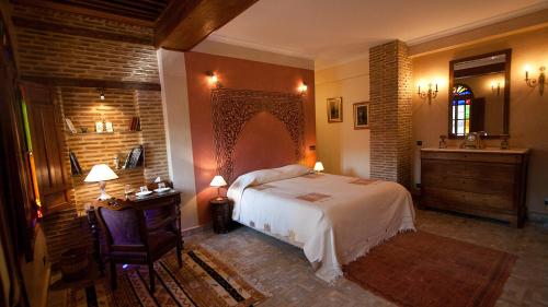 a bedroom with a bed and a table and a sink at Ryad Salama in Fez