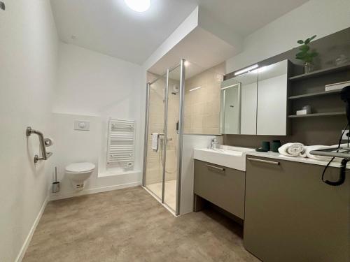 a bathroom with a shower and a sink and a toilet at DOMITYS - Les Cristaux in Le Creusot