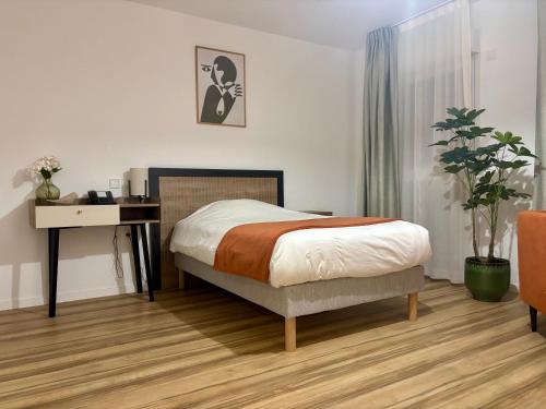 a bedroom with a bed and a desk and a desk at DOMITYS - Les Cristaux in Le Creusot