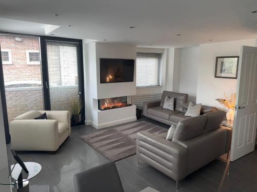 a living room with a couch and a fireplace at LUXURY Apartment Belfast City Centre overlooking Custom House Square in Belfast