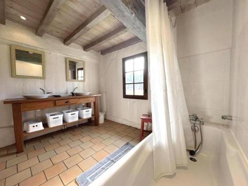 a bathroom with a bath tub and a sink at Le bourrut in Luglon