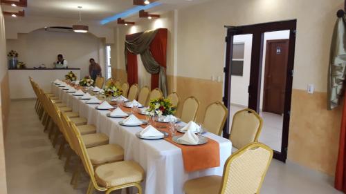 una mesa larga en una habitación con sillas amarillas en Veranda Hotel, en San Pedro Sula