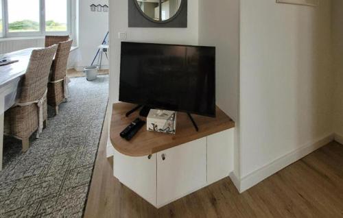 a living room with a flat screen tv on a cabinet at Superbe Appartement Vue Mer in Dunkerque