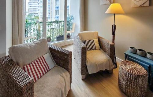 a living room with wicker chairs and a lamp at Superbe Appartement Vue Mer in Dunkerque
