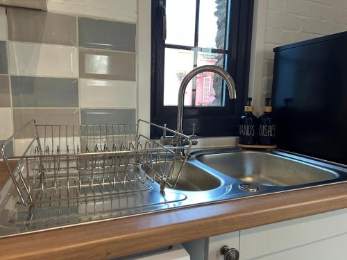 a kitchen sink with a dish drying rack on it at Hele Bay Cottage in Ilfracombe