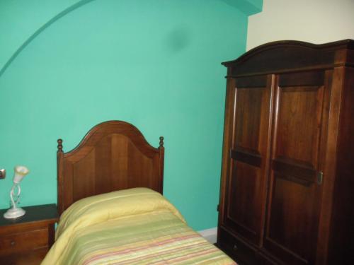 a bedroom with a bed and a wooden cabinet at B&B Il Laghetto in Serra San Bruno