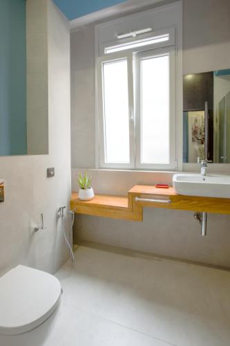 a bathroom with a toilet and a sink and a window at Gran Marina Suites in Las Palmas de Gran Canaria