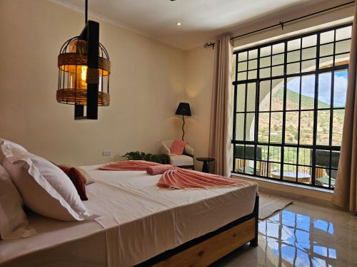 a bedroom with a bed and a large window at Villa Miamba in Zame