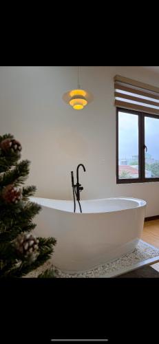 a white bath tub in a bathroom with a christmas tree at Tue Anh Homestay in Cồn Giả Viên