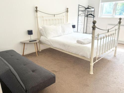 a bedroom with a white bed with a metal frame at Large 2 bedroom house in Wombridge