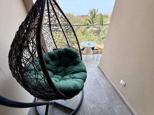 a swing chair sitting in a room with a balcony at Sublime appartement avec Piscine, 2 chambres au Point E, Dakar in Dakar