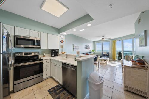 a kitchen with white cabinets and a view of the ocean at Silver Beach 104 PET FRIENDLY! in Orange Beach