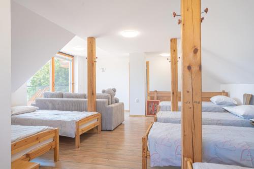 a room with four beds and a couch at Vineyard Cottage Vrbek in Roginska Gorca
