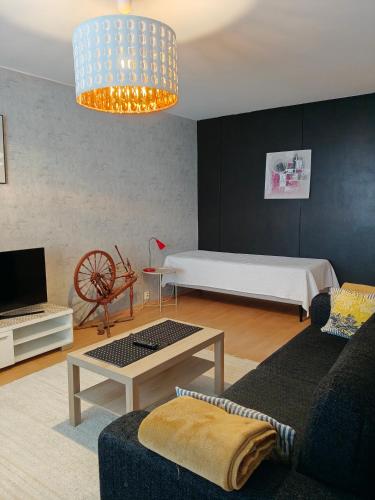un soggiorno con divano e letto di Peaceful and spacious apartment with free parking a Kemi