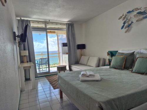a bedroom with a bed with a view of the ocean at On Ze Rock in Le Diamant