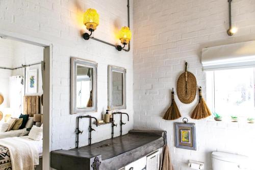 a bathroom with a sink and a white brick wall at The Bay Cottage in Pringle Bay