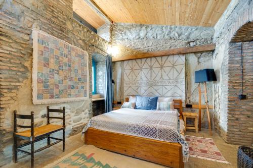 a bedroom with a bed and a stone wall at Lost Ridge Inn, Brewery & Ranch in Sighnaghi