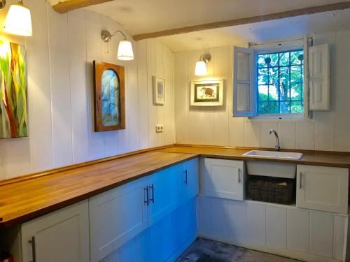a kitchen with blue and white cabinets and a sink at Charming villa with a private pool in Las Rozas de Madrid
