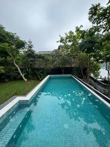 a swimming pool with blue water in a yard at Charlie in Ambalangoda