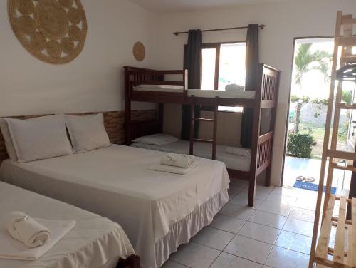 a room with two beds and a balcony with at Torre do Sol in Praia do Frances