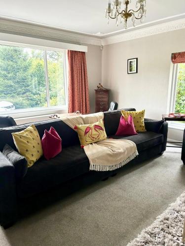 a living room with a black couch with colorful pillows at Alloa in Newby Bridge