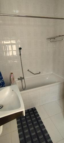 ein weißes Badezimmer mit Badewanne und Waschbecken in der Unterkunft Sunlight house in Marsaskala