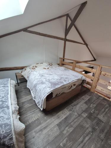 a bedroom with a bed and a wooden floor at Gîte de La Forge in Hesse
