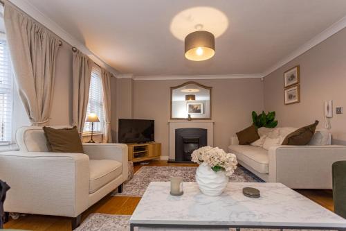 a living room with white furniture and a vase of flowers at Kirkwood Drive in Durham
